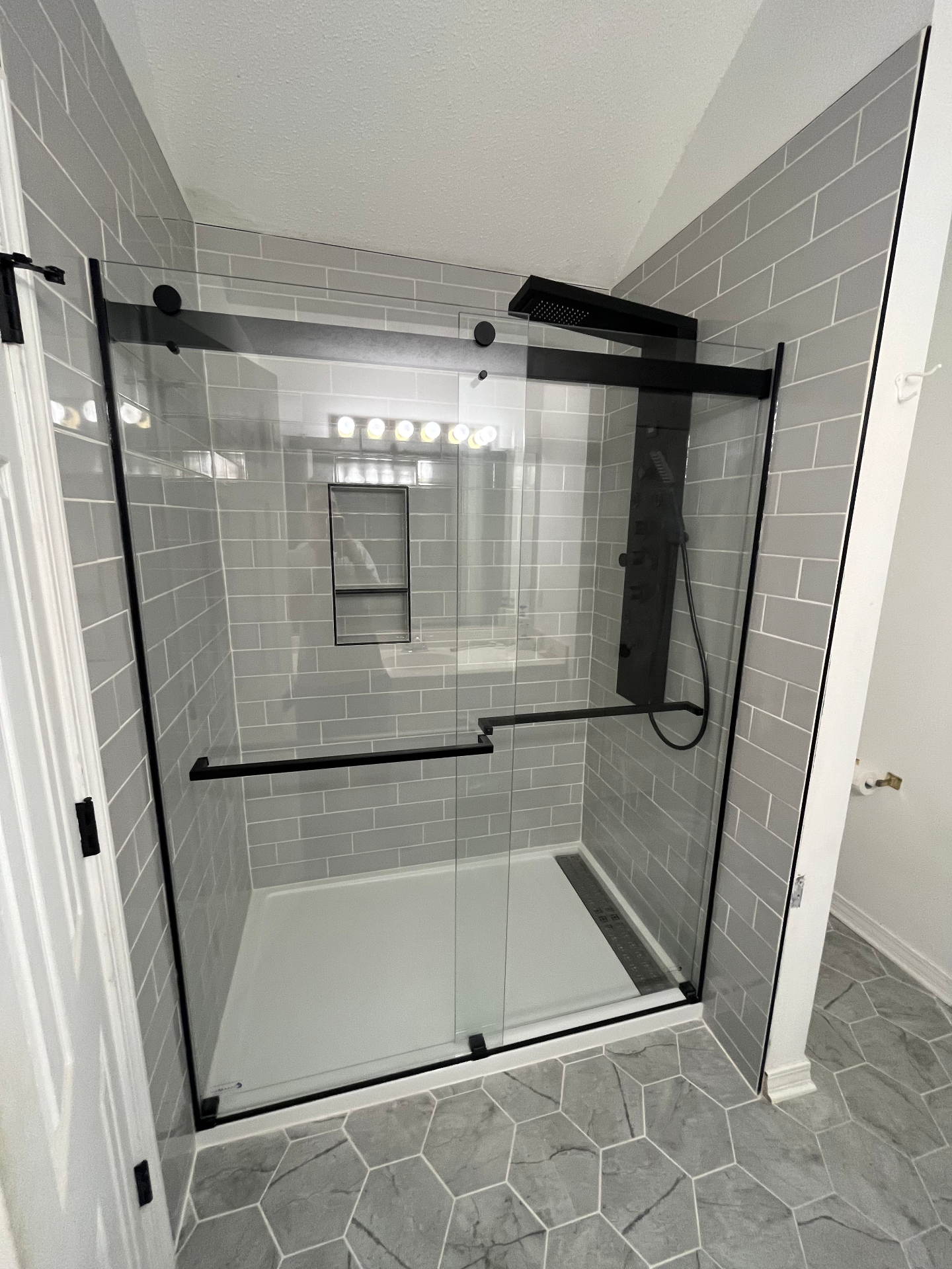 Modern grey tile shower with sliding glass door